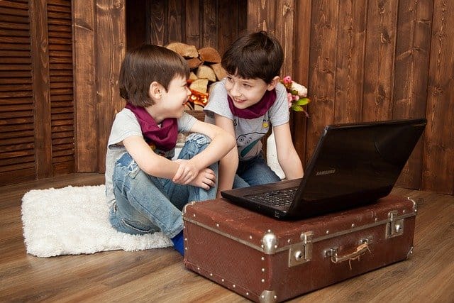 Niños felices estudiando en computador